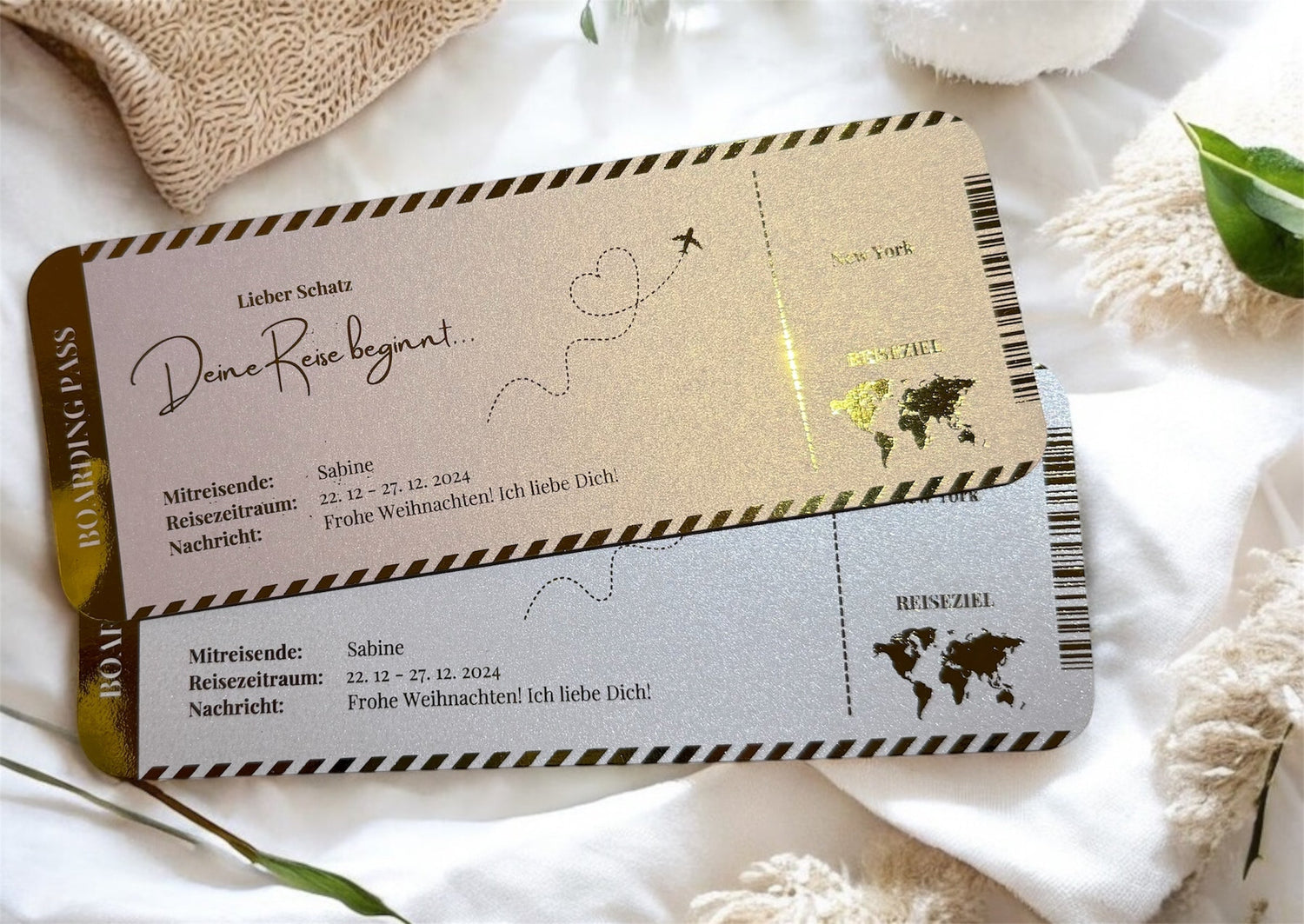 Zwei Tickets in weiß und perlmutt Rosa auf einer weißen Decke